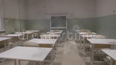 空教室，有木制课桌，学校里有白色和绿色的粉笔板。 空教室。 废弃的学校教室